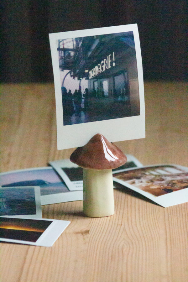 Handmade mushroom shaped picture holder out of clay, perfect for displaying photos and adding charm to home decor.